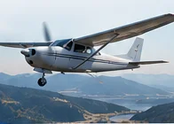 A small propeller aircraft flying over mountains